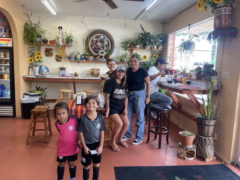 Family with two kids in soccer uniforms in the dining room