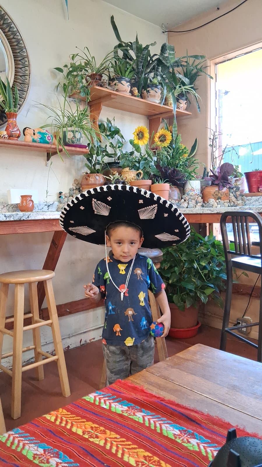 A little boy in a big sombrero inside the store