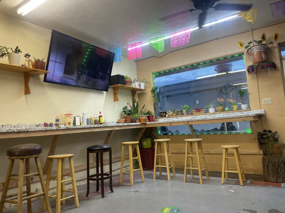 Inside dining counter with stools, papel picado and plants