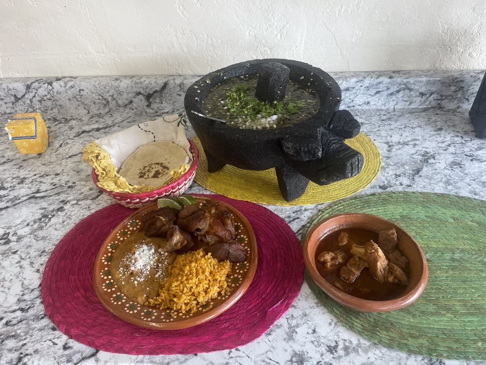 Carnitas plate with rice and beans, a molcajete of salsa and handmade tortillas