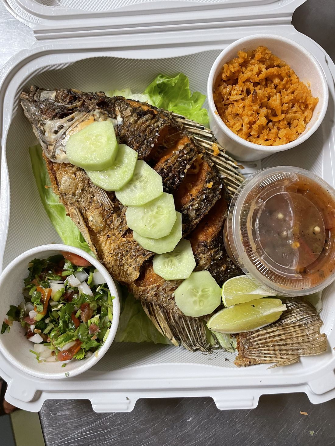 Fried whole mojarra with rice, pico de gallo, salsa and lime