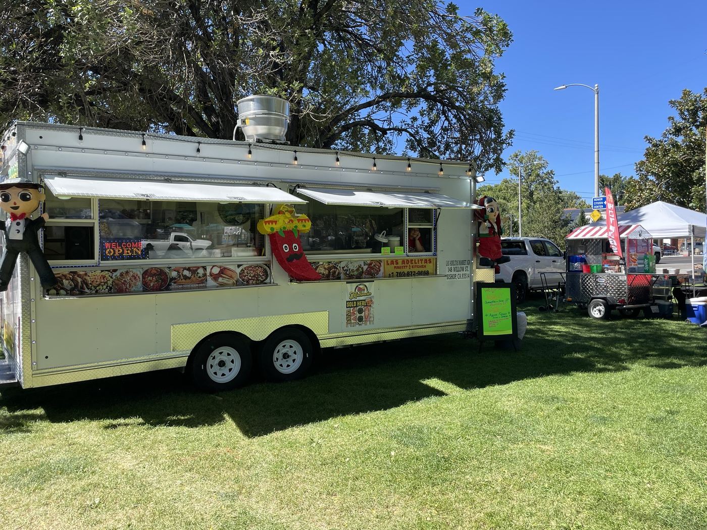 The Las Adelitas truck set up on the grass at an outdoor event in Bishop